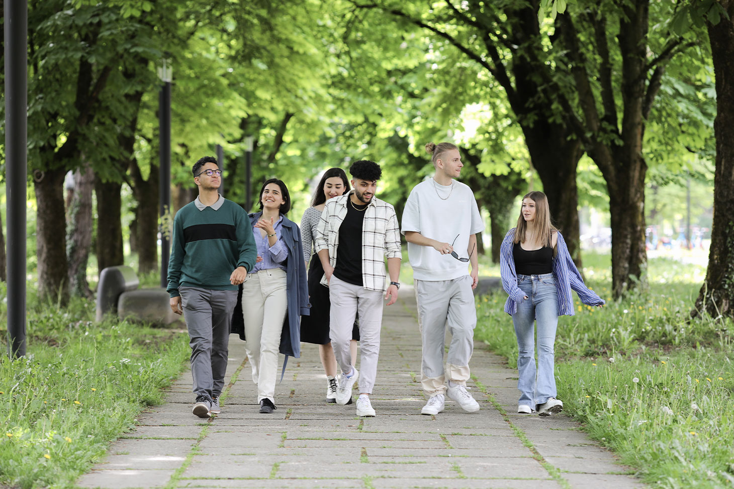 Des étudiants déambulent dans les allées ombragées du campus de Saint-Martin-d'Hères